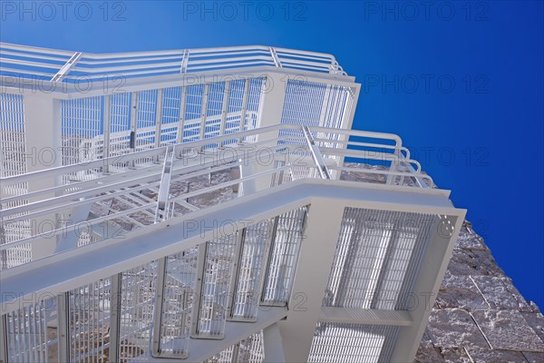 Low Angle View of White Fire Escape against Blue Sky