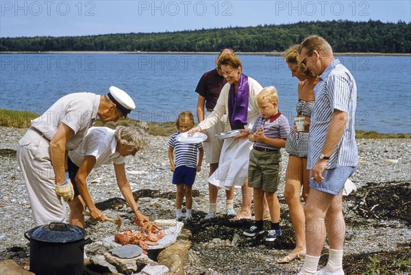 Group of people enjoying a beach picnic with Lobsters