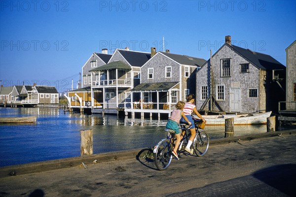 Two Young Girls riding Tandem Bicycle