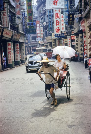 Man pulling Woman in Rickshaw