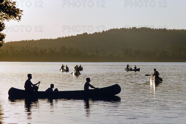 Silhouette of boys in Canoe Boats at Sunset