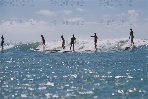 Silhouette of Surfers riding a Wave