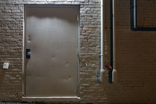 White Metal Door and White Brick Wall Exterior at Night