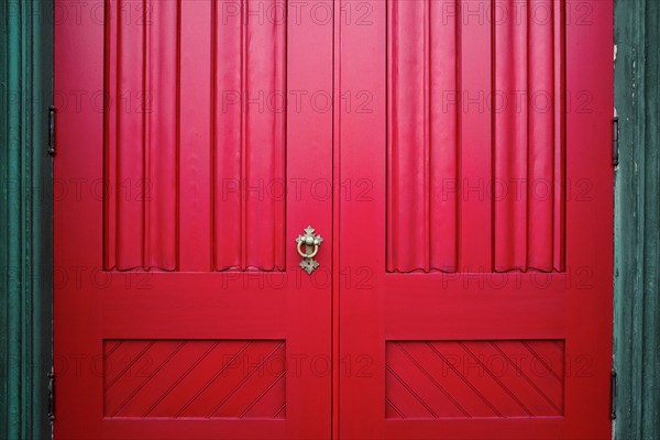 Red Wood Doors with Ornate Metal Handle