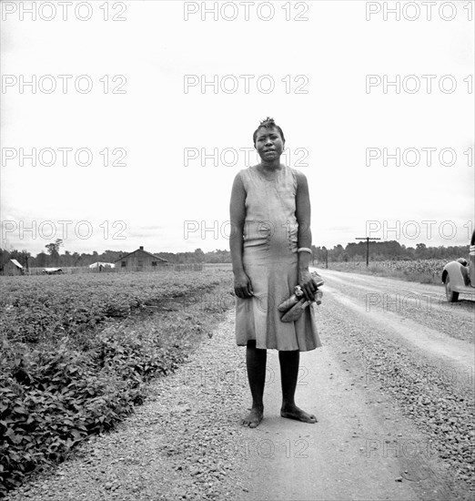 Full-Length Portrait of Woman carrying her Shoes Home  from Church