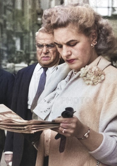 Half-Length Portrait of Woman reading Newspaper on Sidewalk