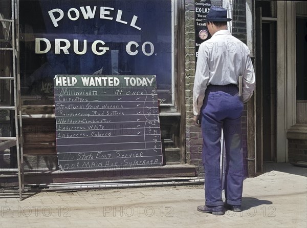 Man looking at Help Wanted Sign in Store Window