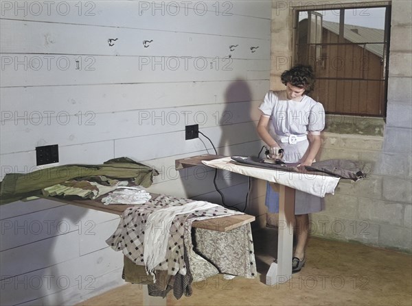 Young Adult Woman ironing Clothes at Laundry Facilities in Utility Building