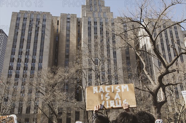 Racism is a Virus Sign against buildings