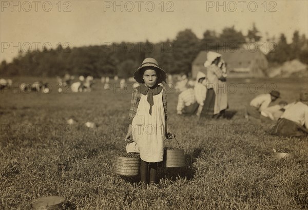 Young girl carrying buckets of Cranberries