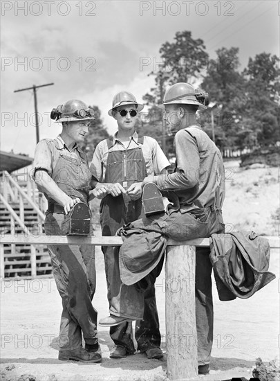 Three construction workers on break during construction of Douglas Dam