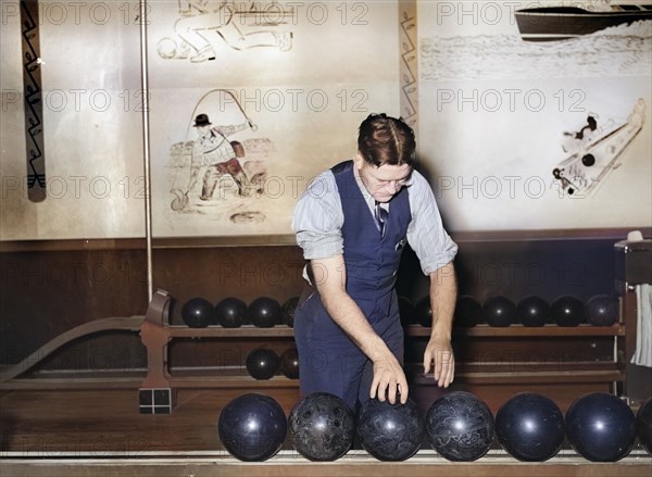 Man choosing bowling ball at bowling alley