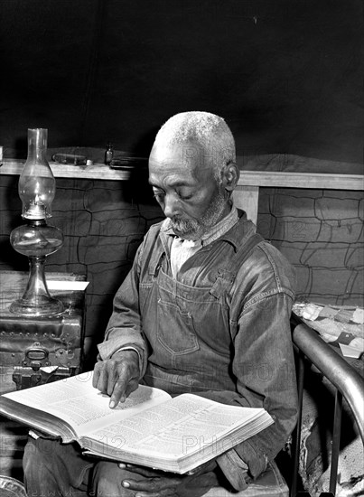 Evicted sharecropper reading bible