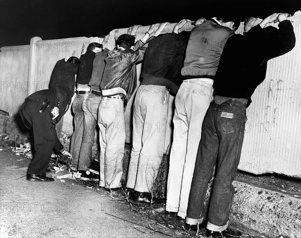 Seven men line up on fence