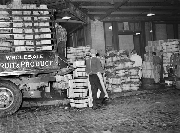 Workers loading green vegetables at produce market