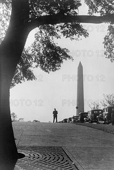 Silhouette of man alongside row of parked cars