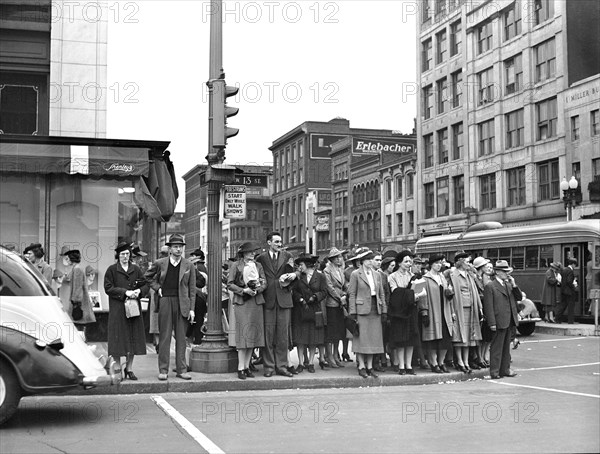 Pedestrians waiting at stoplight to cross street