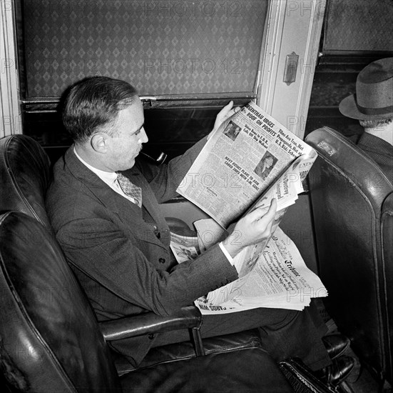 Commuter reading newspaper on train to New York City