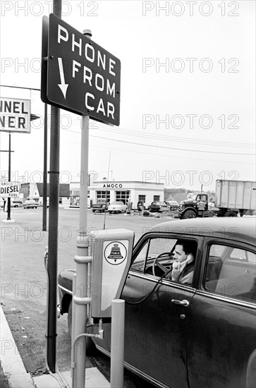 Man in car using a drive-in telephone