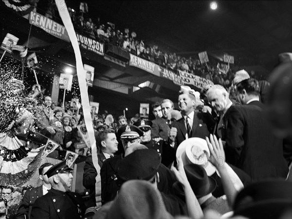 U.S. Senator John F. Kennedy surrounded by cheering supporters at Boston Garden on night before election day