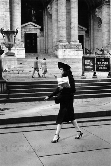 Woman walking in front of New York Public Library