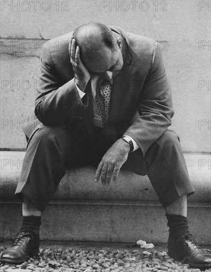 Man sitting with head resting on hand