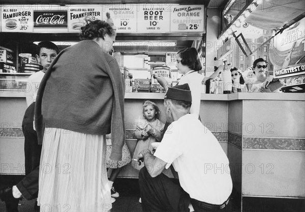 Group of people gathered around fast food restaurant counter