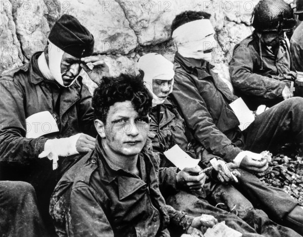 American Assault Troops of the 16th Infantry Regiment, Injured while storming Omaha Beach, wait by Chalk Cliffs for evacuation to Field hospital, Collville-sur-Mer, Normandy, France, U.S. Army Signal Corps, June 6, 1944