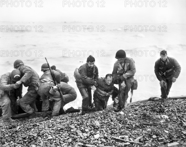 Surviving members of American landing party, whose landing craft was sunk by enemy action, reaching Utah Beach by using life raft, near Cherbourg, Normandy, France, U.S. Army Signal Corps, June 6, 1944