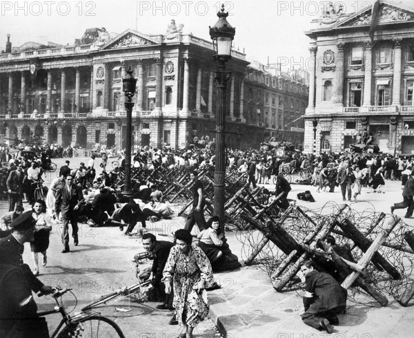 Crowds of Parisians celebrating the entry of Allied troops scattering for cover as sniper fires from building on the Place de la Concorde, Paris, France, U.S. Army Signal Corps, August 26, 1944
