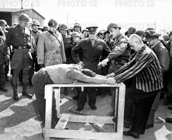 U.S. General Dwight D. Eisenhower, with U.S. Generals Omar Bradley and George Patton (at right) watching grimly while occupants of German concentration camp demonstrate how they were tortured by Nazi personnel, near Gotha, Germany, U.S. Army Signal Corps, April 12, 1945