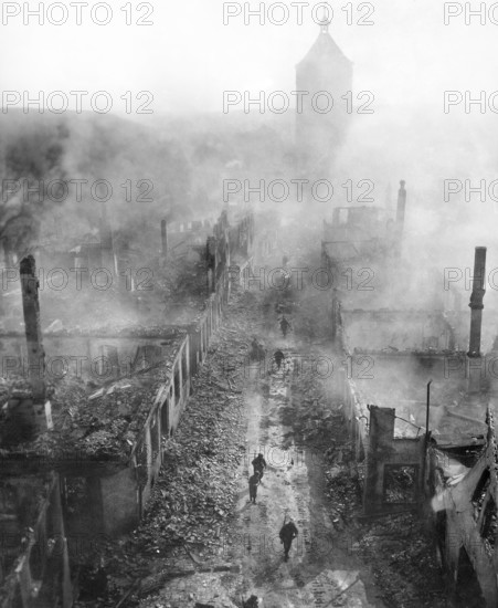 U.S. infantrymen of the 255th Infantry Regiment moving down street to hunt out Hun after recent raid by U.S. 63rd Division, Waldenburg, Germany, U.S. Army Signal Corps, April 16, 1945