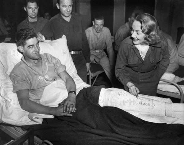 Marlene Dietrich, motion picture actress, autographing cast of Tec 4 Earl E. McFarland of Cavider, Texas, at U.S. hospital in Belgium, where she has been entertaining the GI's, U.S. Army Signal Corps, November 24, 1944