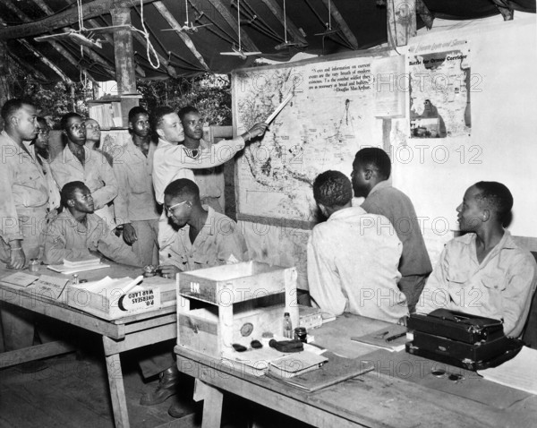 Members of U.S. 477th Anti-aircraft Artillery, Air Warning Battalion, studying maps in operations section, Oro Bay, Oro Province, Papua New Guinea, U.S. Army Signal Corps, November 15, 1944