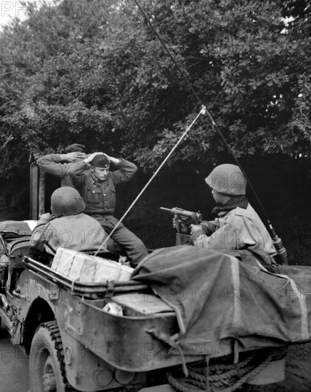 Two German prisoners of war being taken to U.S. 6th Division Prisoner of War Encampment for interrogation and searching, Plouay, France, U.S. Army Signal Corps, August 28, 1944