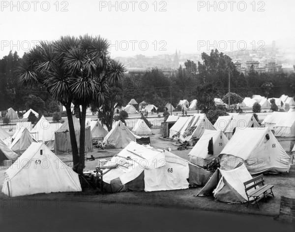 Refugee camp established after earthquake in Jefferson Park in vicinity of Eddy and Gough Streets; the large church tower shown on right is Sacred Heart Church, Fillmore and Fulton Streets, San Francisco, California, USA, U.S. Army Signal Corps, 1906