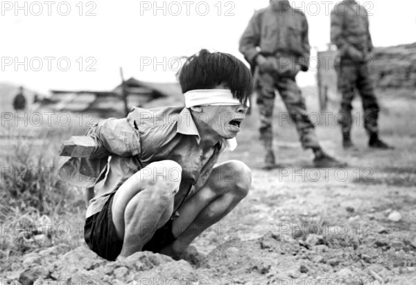 Viet Cong prisoner awaiting interrogation at A-109 Special Forces Detachment, Thuong Duc, South Vietnam, U.S. Army Signal Corps, January 23, 1967