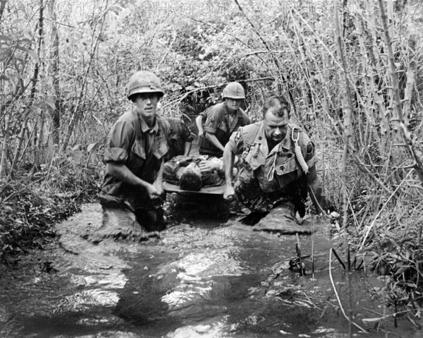 U.S. soldiers carrying wounded comrade through swampy area, Vietnam, U.S. Army Signal Corps, 1969