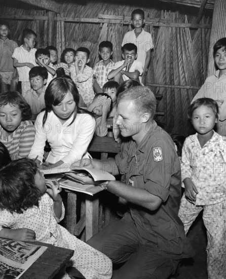 Private First Class, Alan Wondra conducting class in English at Vietnamese school during civic action program of U.S. 199th Infantry Brigade, Cat Lai, Vietnam, U.S. Army Signal Corps, August 30, 19667