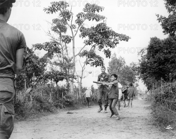 Members of U.S. 3rd Battalion, 187th Infantry, 101st Airborne Division (Airmobile), join children in game of baseball, Ap Uu Thoung, Vietnam, U.S. Army Signal Corps, January 15, 1970