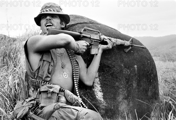 Specialist. 4 Richard Champion, squad leader, Company B, 4th Battalion, 21st Infantry, 11th Light Infantry Brigade, shouting instructions to squad after receiving sniper fire while on patrol on Hill 56, 70 miles southeast of Chu Lai, Vietnam, U.S. Army Signal Corps, January 19, 1971