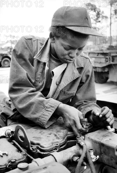 Private Lawanna Simpson, auto mechanic, 724th Maintenance Battalion, working on U.S. Army 5-ton truck engine, Fort Stewart, Georgia, USA, U.S. Army Signal Corps, April 18, 1980