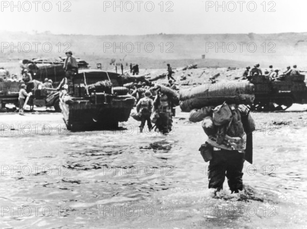 American assault troops with full amphibious military equipment moving onto Omaha Beach, Colleville-sur-Mer, Normandy, France, U.S. Army Signal Corps, June 6, 1944