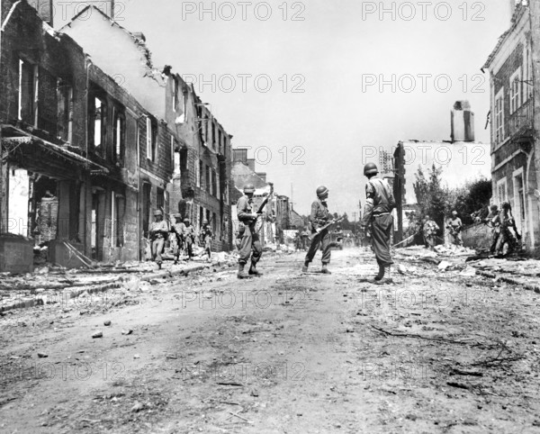 U.S. infantrymen moving through street ruins, Percy, France, U.S. Army Signal Corps, August 2, 1944