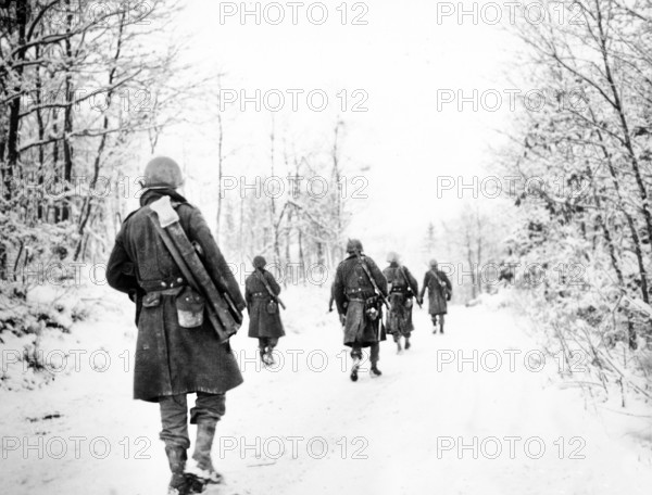 American soldiers of the Company I, 333rd Infantry Regiment, 84th Division moving up to new positions through snow covered countryside, near Forge a la Plez, Manhay, Belgium, U.S. Army Signal Corps, January 5, 1945