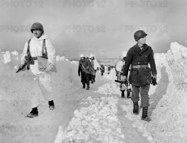 U.S. infantrymen of an armored division marching up snowy road southeast of Born, Belgium, U.S. Army Signal Corps, January 22, 1945