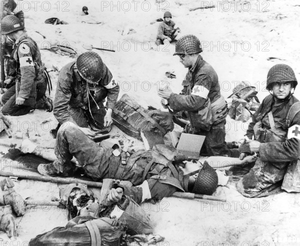 American medics rendering first aid to troops in initial landing on Utah Beach, Les Dunes de Madeleine, Normandy, France, U.S. Army Signal Corps, June 6, 1944