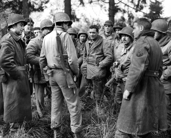 American soldiers from 28th Division Band and Quartermaster Company, who fought Germans in Wilts, Belgium until their ammunition was exhausted, gather at Bastogne, Belgium, U.S. Army Signal Corps, December 20, 1944