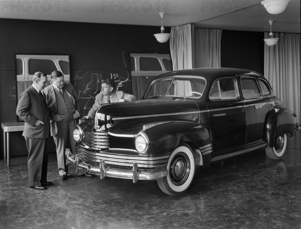 Norman Bel Geddes and Nash-Kelvinator corporation officials inspecting a marked-up model of a new car, Detroit, Michigan, USA, Arthur S. Siegel, U.S. Farm Security Administration, 1939