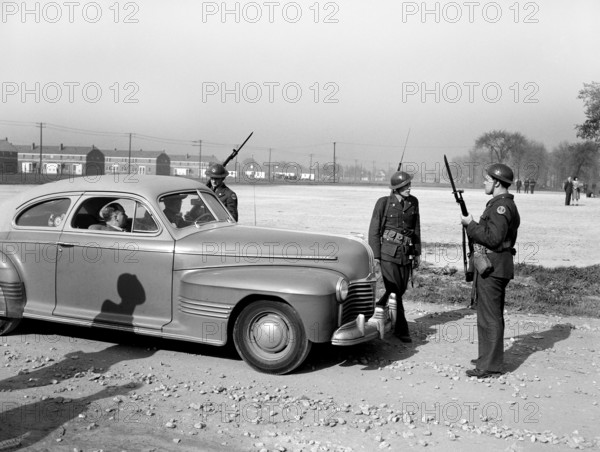 Home guard troops with bared bayonets preventing cars from entering Sojourner Truth Homes, a U.S. Federal Housing Project, during riot caused by white neighbors' attempting to prevent black tenants from moving in, Detroit, Michigan, USA, Arthur S. Siegel, U.S. Office of War Information, February 1942